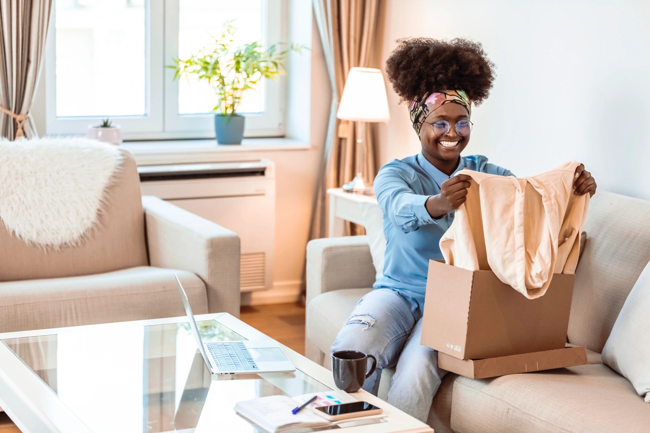 Customer unboxing a parcel on a sofa