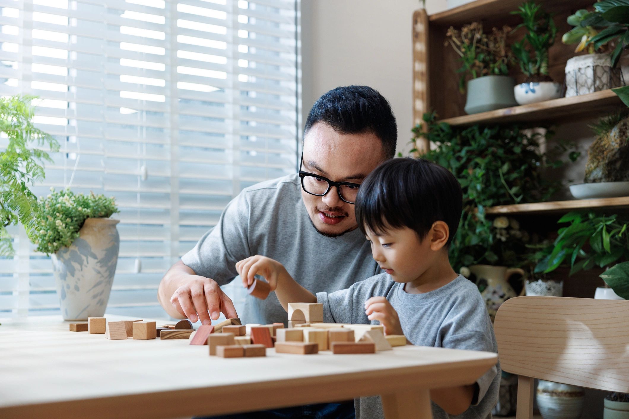 Parent and child playing with a toy at a table